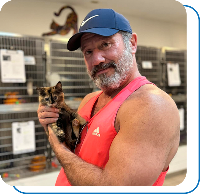 Buff man holding tiny kitten